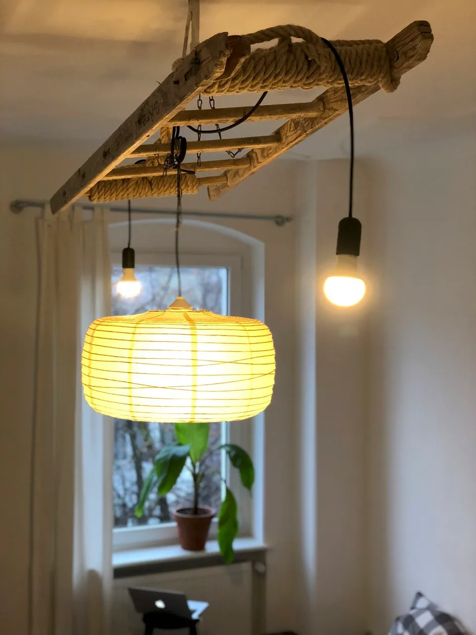 Chandelier installation with an old painters ladder